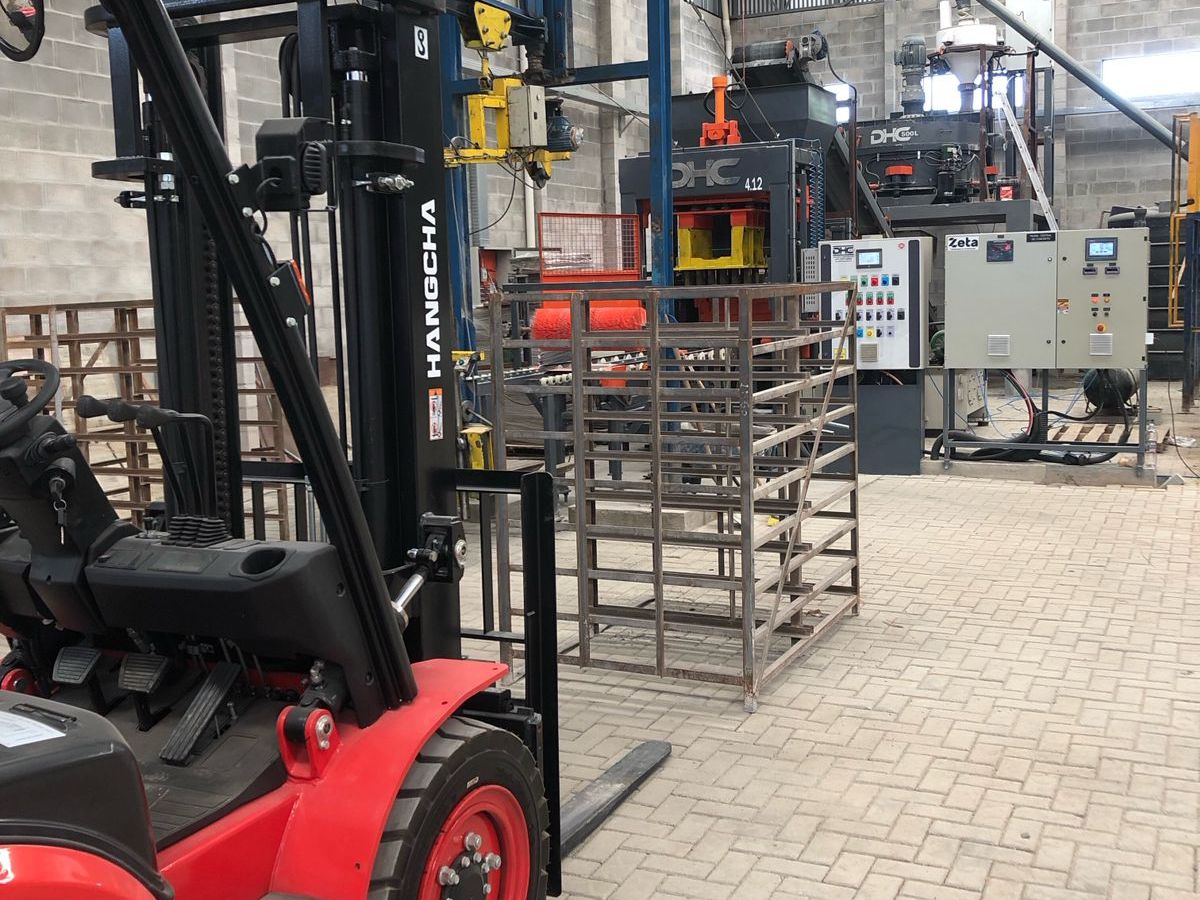 Interior da fábrica Termobloco com empilhadeira e prensa